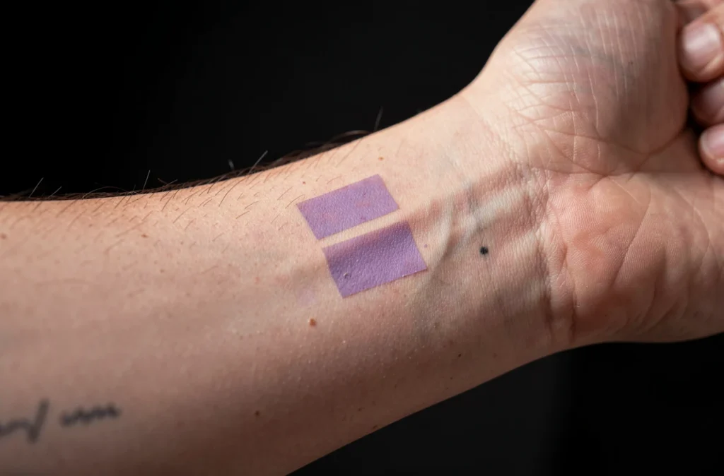 Avant-bras tatoué avec une légère trace violette de stencil